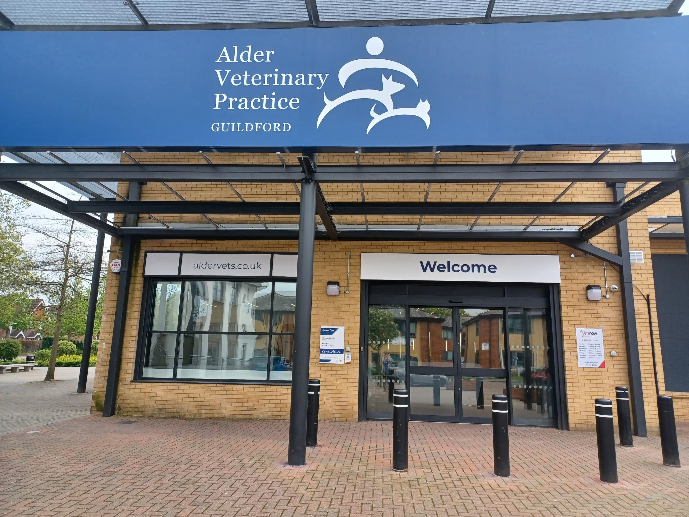 Entrance to Alder Veterinary Practice in Guildford, featuring a brick building with a welcome sign, website address  Entrance to Alder Veterinary Practice in Guildford, featuring a brick building with a welcome sign, website address