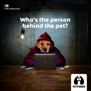 A dog head on a hooded figure uses a laptop in a dimly lit room. Text reads, 