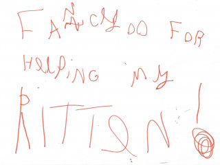 Child's handwritten message in red crayon on white paper reads: 