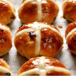 glazed-hot-cross-buns Close-up of golden brown hot cross buns with a shiny glaze.