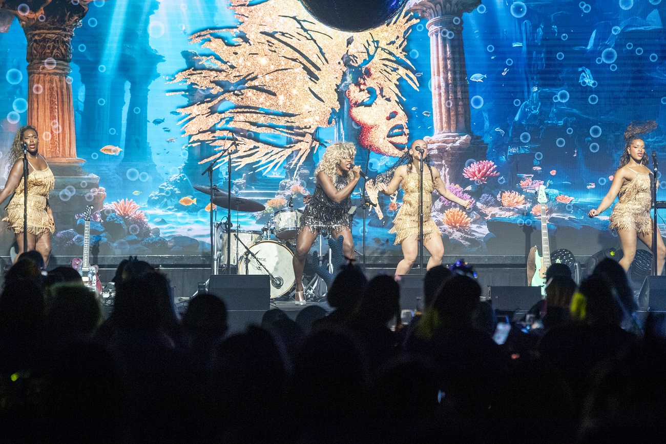Live band performing on a vibrant, underwater-themed stage at a Vets Now event, bringing energy and excitement to the crowd.