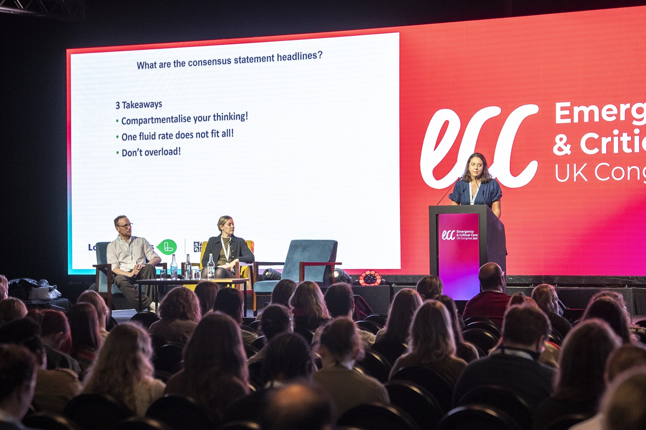 Speaker presenting clinical insights on stage at the Vets Now ECC UK Congress, with delegates engaged in learning.