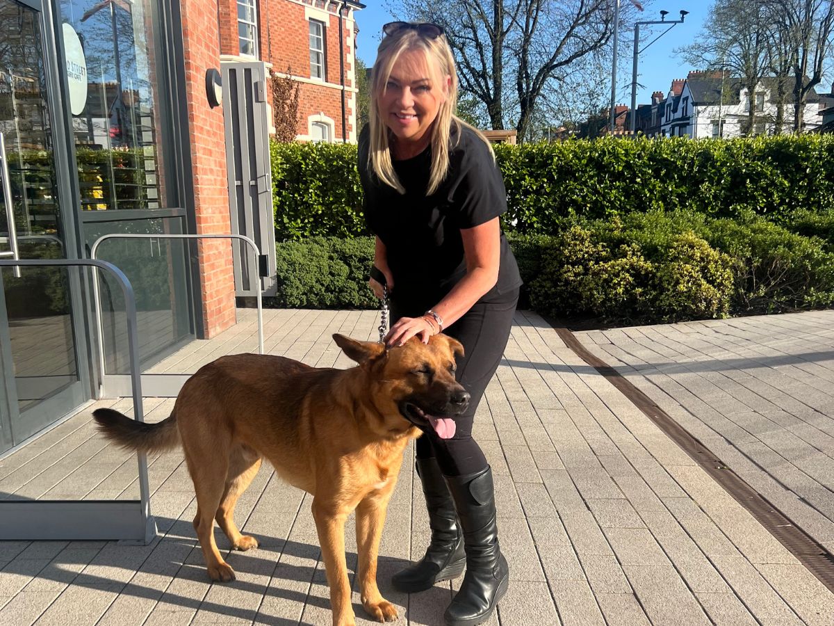 Elaine crouching down to stroke her dog Sidney