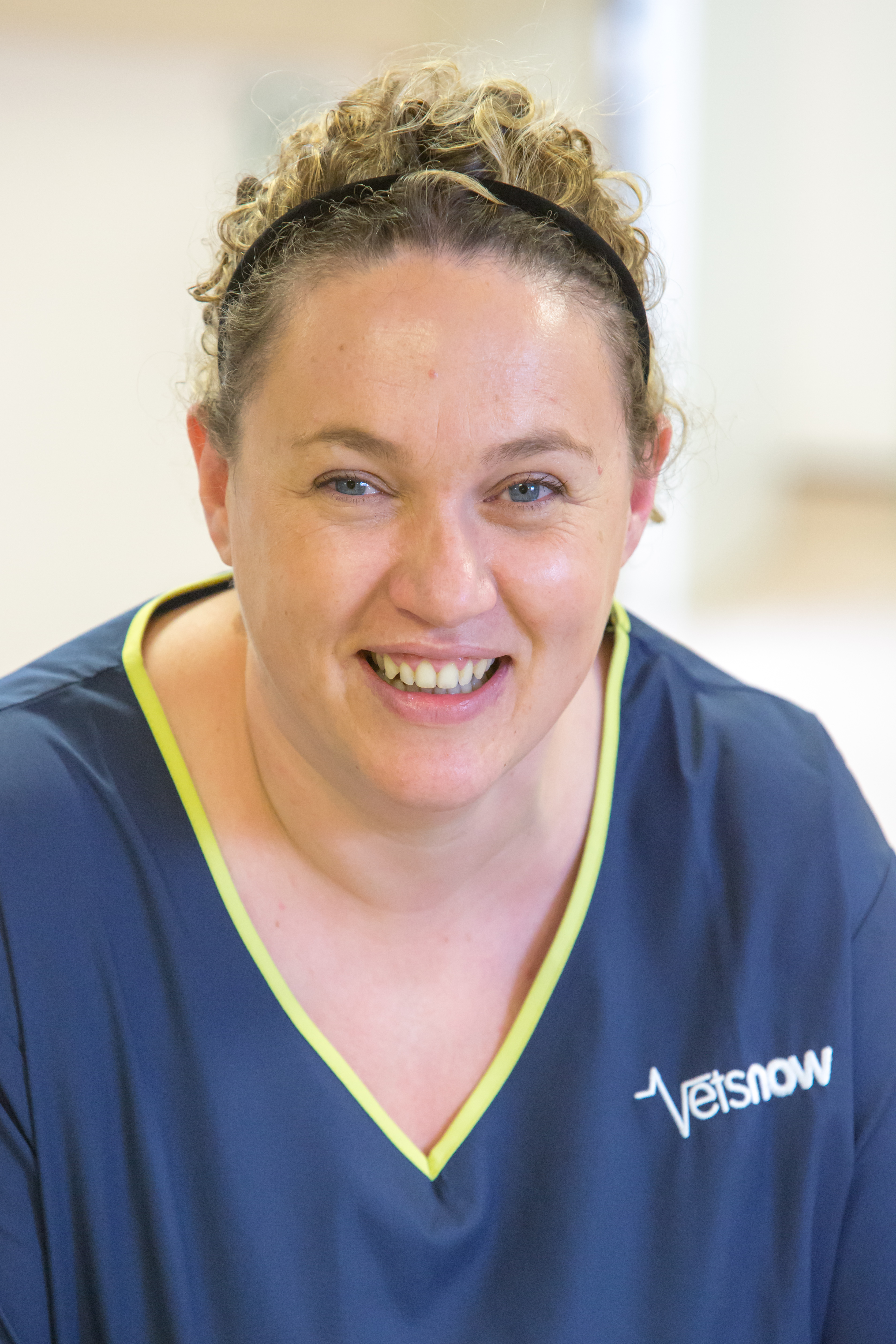 A veterinary hospital's entrance features signage reading Emergency Veterinary Clinic and Vets Now Hospital above large glass doors on a sidewalk, surrounded by black and beige building walls.