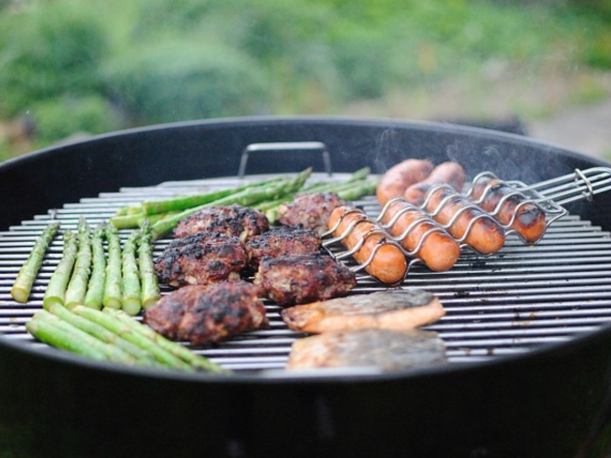 A bbq with assorted meat and veg on the hot grill