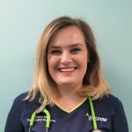 Claire Hill smiling in Vets Now uniform with a green stethoscope around her neck.