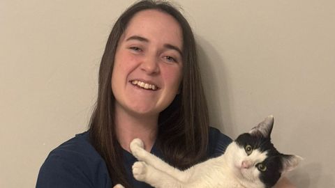 Image of vets now vet Kate Campbell holding a cat in her arms